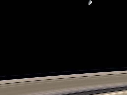 Saturn's icy moon Enceladus hovers above its rings