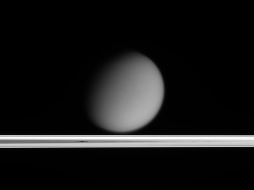 Titan appears to drift above Saturn's ringplane