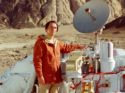 Carl Sagan poses with a model of the Viking lander.