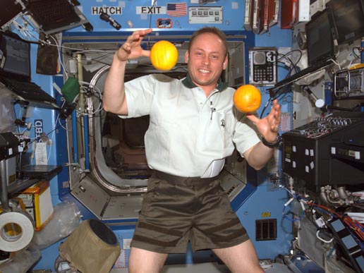 Astronaut Edward M. (Mike) Fincke, Expedition 9 NASA ISS science officer and flight engineer, juggles fresh fruit in the Destiny laboratory. Photo credit: NASA/Johnson Space Center.